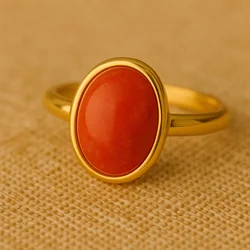 Gros plan bague corail sertie or